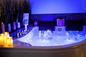 Boblebad med vandjets, stearinlys og en massagestol.