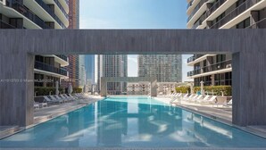 Ein Dachpool mit Liegestühlen und Blick auf hohe Gebäude.