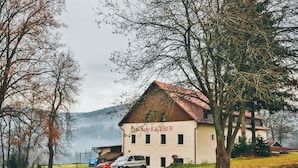 Ein Gebäude mit rotem Dach und einem Schild mit der Aufschrift 'Hotel Kacerov'.