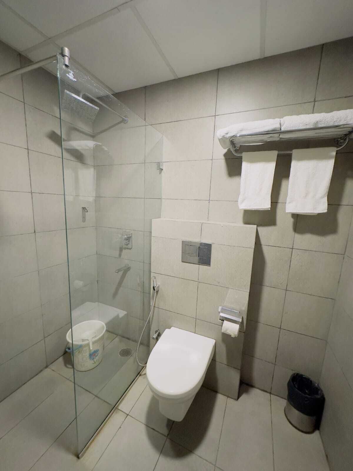 Kylpyhuone, jossa on lasiseinällä varustettu suihku, wc ja pesuallas.
