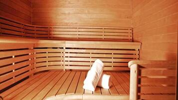 A wooden sauna with benches and a towel on the floor.