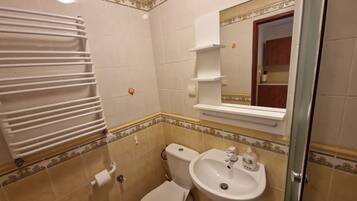 Une salle de bain équipée de toilettes, d’un lavabo et d’un porte-serviettes.