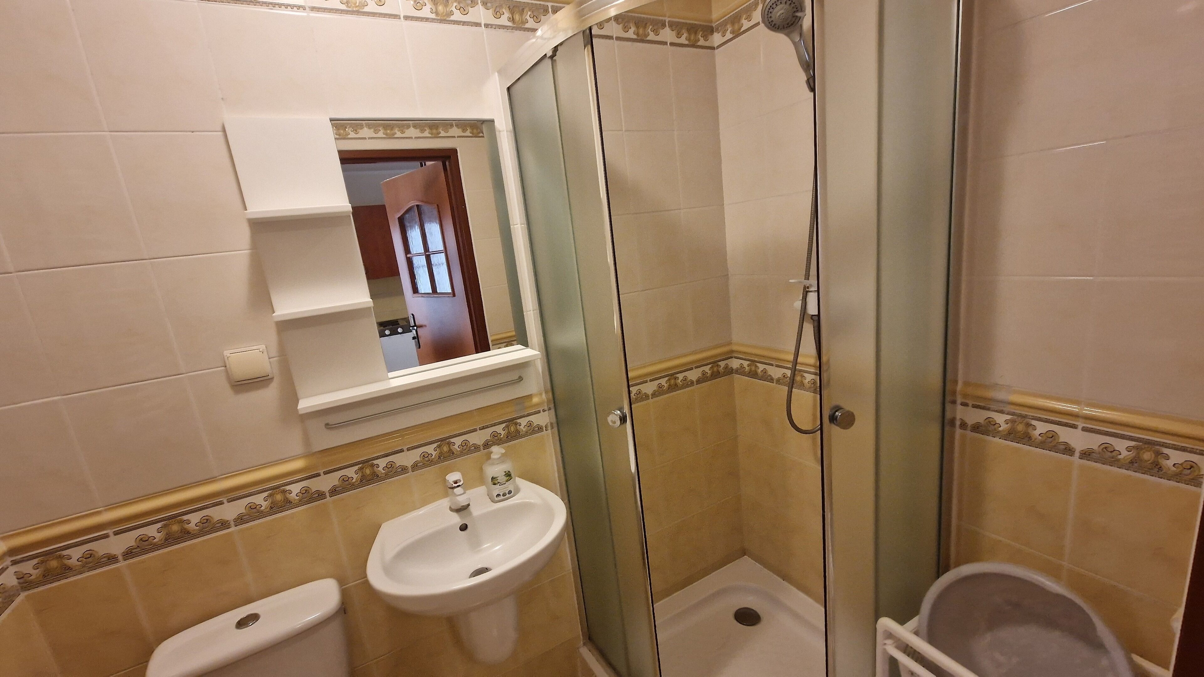 Ein Badezimmer mit einer Duschkabine, einem Waschbecken und einer Toilette.