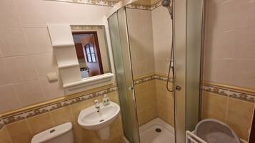 Ein Badezimmer mit einer Duschkabine, einem Waschbecken und einer Toilette.
