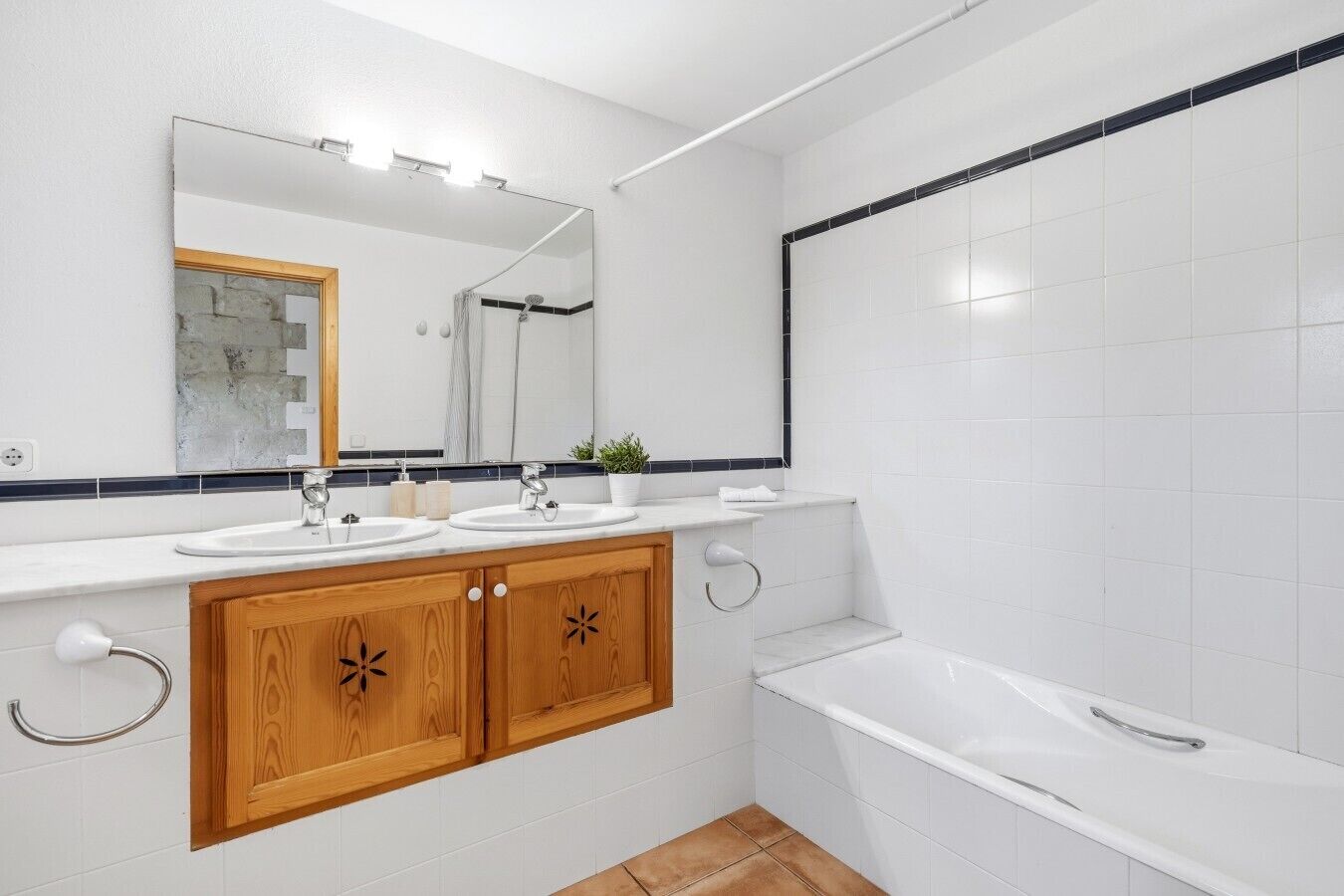 Une salle de bain moderne avec deux lavabos, un grand miroir et une baignoire.
