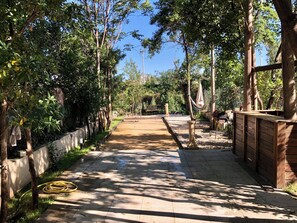 A paved pathway lined with trees and a hammock, leading to a distant seating area. - T2 Apartment with a Private Terrace and Shared Garden   (Marseille)