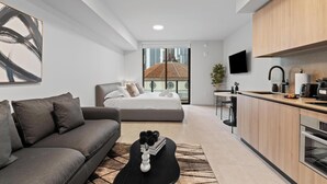 Eine moderne Wohnung mit Wohnbereich, Schlafzimmer mit Blick, Küche und Essbereich.