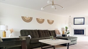 A modern living room with a sectional sofa, a coffee table, and a fireplace. - Shoreham Luxe - Vibrant 4BR\2.5BA with Waterfront (Evansville)