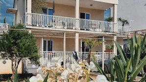 Ein zweistöckiges Gebäude mit Balkon und überdachter Außenbereich-Sitzgelegenheit.