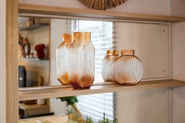 A mirror reflecting three glass vases on a shelf. - Host Stay Long View Lodge (Morpeth)