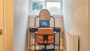 Un petit bureau comprenant un bureau, une chaise, un ordinateur et une fenêtre.
