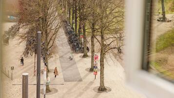 A pedestrian walkway lined with trees and bicycles parked on the side.