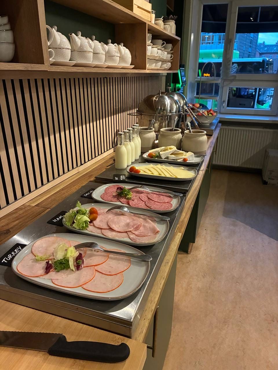 A buffet setup with various food items and utensils.