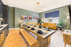 A modern kitchen with a central island, wooden cabinets, and a dining area with a bench. - Host Stay The Georgian Quarter Catherine Street VI (Liverpool)