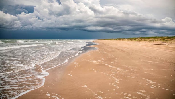 A beach with a wide sandy shore and waves crashing onto it. - Modern Beachside Condo w Pool - South Padre Island (South Padre Island)