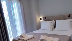 Ein Hotelzimmer mit einem Bett, einem Nachttisch und einem Fenster mit Vorhängen.
