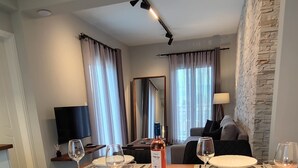 Ein Essbereich mit einem Holztisch, gedeckt für vier Personen, einer Weinflasche und modernem Interieur mit Steinakzenten.
