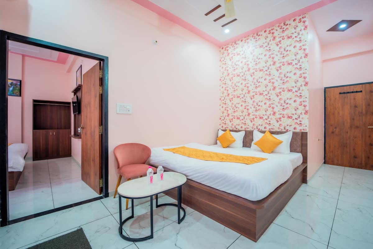Un dormitorio con una cama, una mesita, una silla, un armario y una puerta.