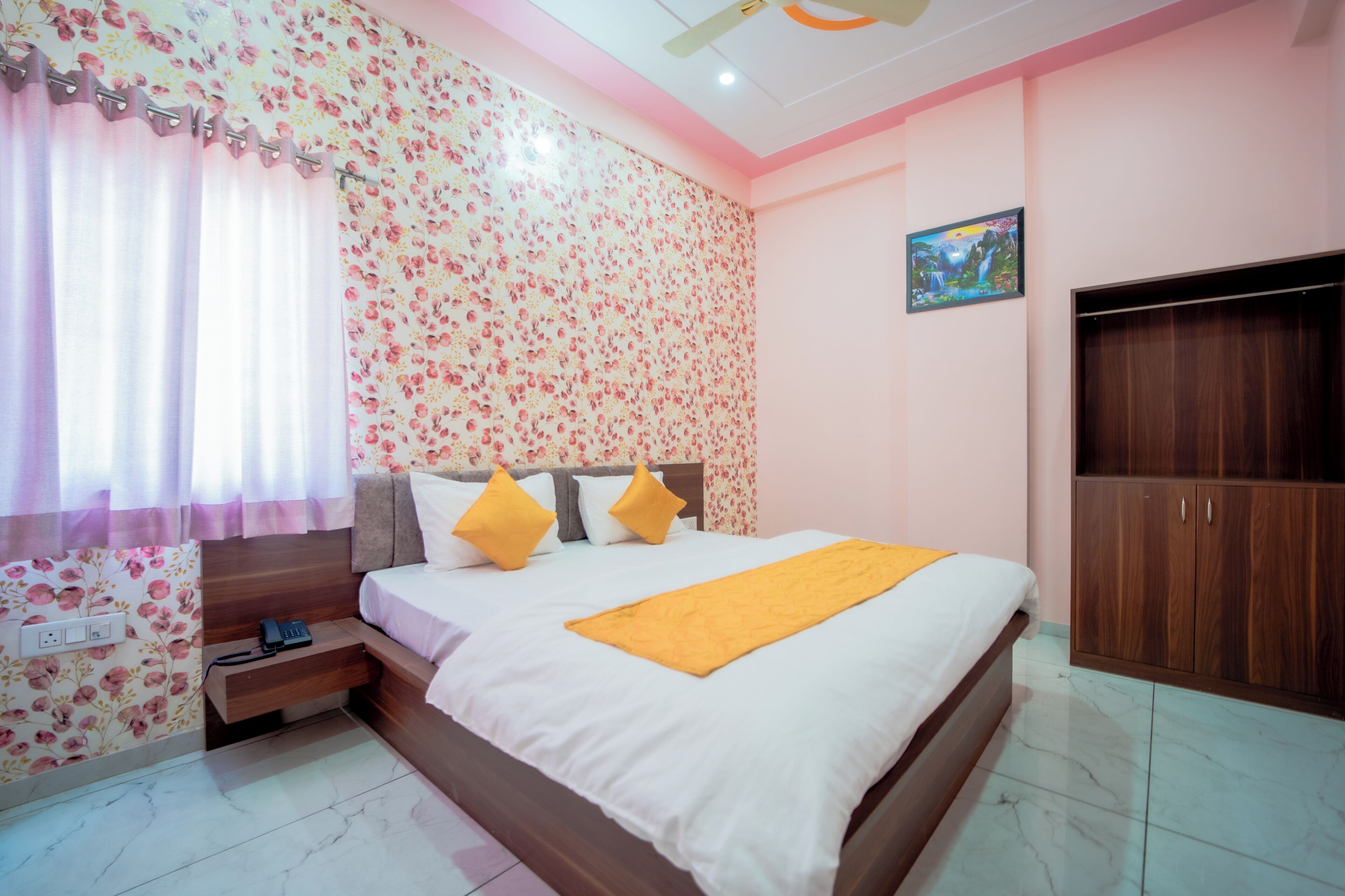 Un dormitorio con cama, mesita de noche, armario y pared con estampado floral.