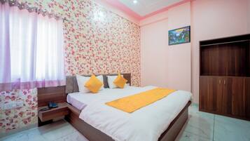 Un dormitorio con cama, mesita de noche, armario y pared con estampado floral.