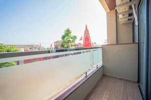 A balcony with a view of a building with a red spire, a clear sky, and a railing. - Hotel Neel Kamal (Khatoo)