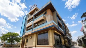 A multi-story hotel with a modern design, featuring balconies and large windows. - Hotel Neel Kamal (Khatoo)