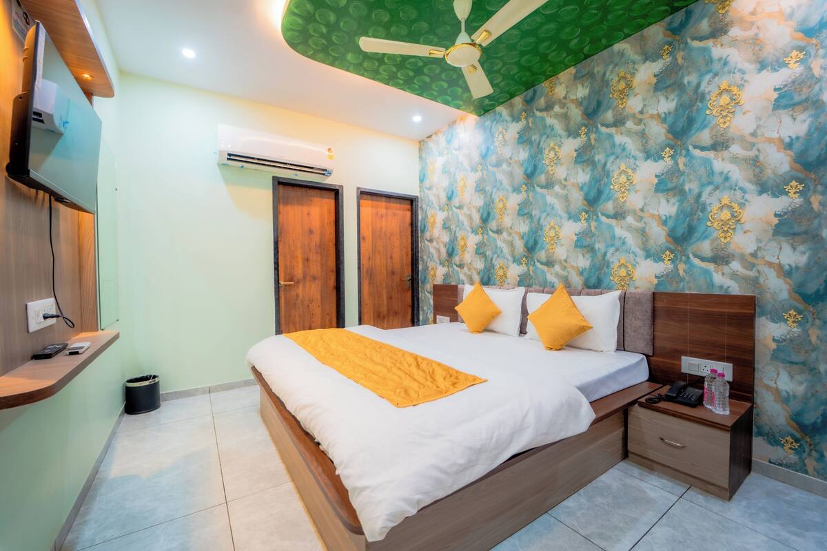 Un dormitorio ordenado con cama, mesita de noche y ventilador de techo.