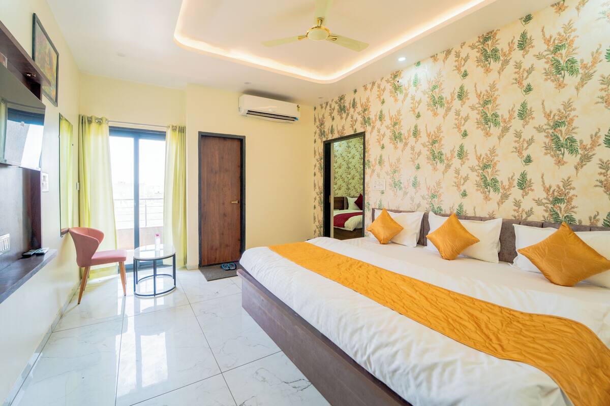 Una habitación de hotel con cama, una silla, una mesa y un ventilador de techo.