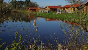 A lakeside lodge with wooden cabins and a small dock. - The Balmoral Studio Lodge – Private Hot Tub & On-Site Carp Fishing 🎣🛁 (Ellesmere)