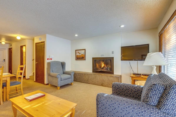 A living room with a fireplace, a television, and a sofa. - Heated Pool Access at Winter Park Base Camp! (Winter Park)