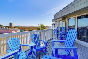 A deck with blue Adirondack chairs and a view of the landscape. - Walk to Beach! Pet-friendly Mustang Island Retreat (Port Aransas)