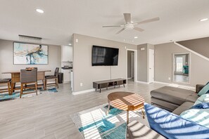 A spacious living area with a dining table, sofa, and TV. - Quiet Suburban Huntsville Home: 8 Mi to Madison! (Harvest)