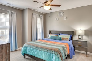 A bedroom with a bed, a nightstand, a ceiling fan, and decorative wall art. - Quiet Suburban Huntsville Home: 8 Mi to Madison! (Harvest)