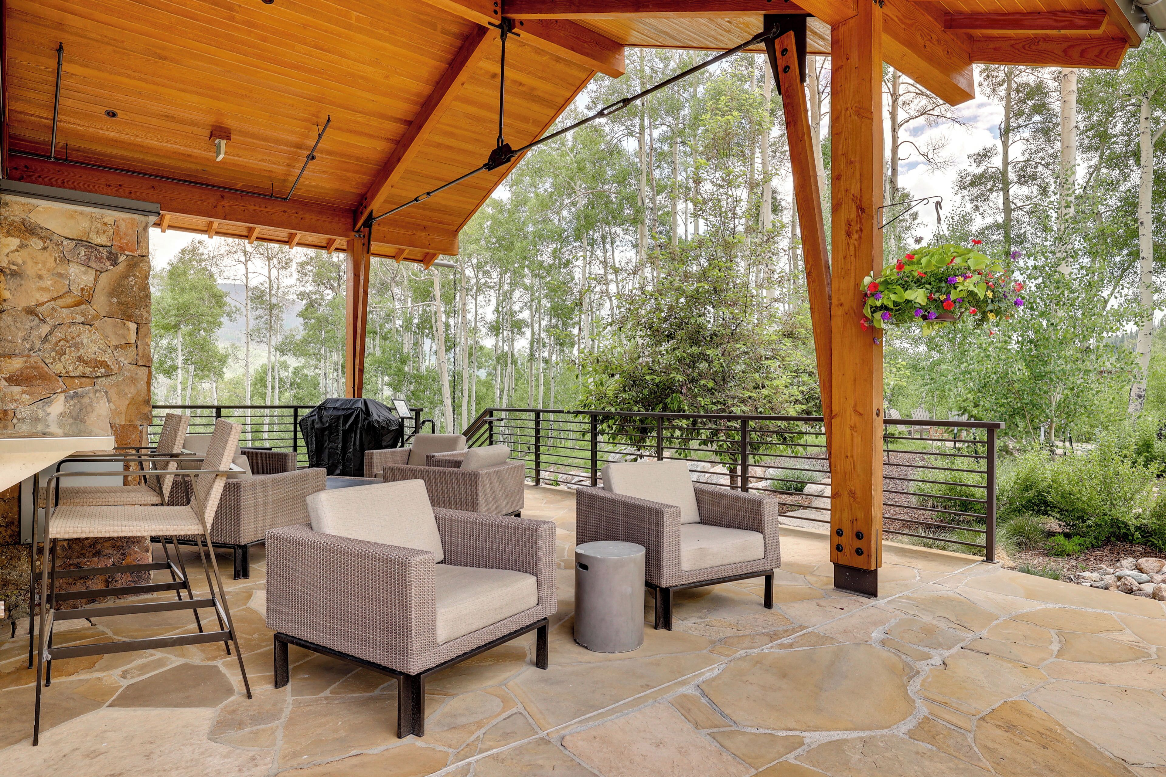 Eine Terrasse im Freien mit Korbmöbeln, Steinboden und Holzboden.