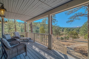 A covered porch with wicker furniture and a view of a forested landscape. - 'the Restful Retreat' Mtn-view Alto Group Getaway (Alto)