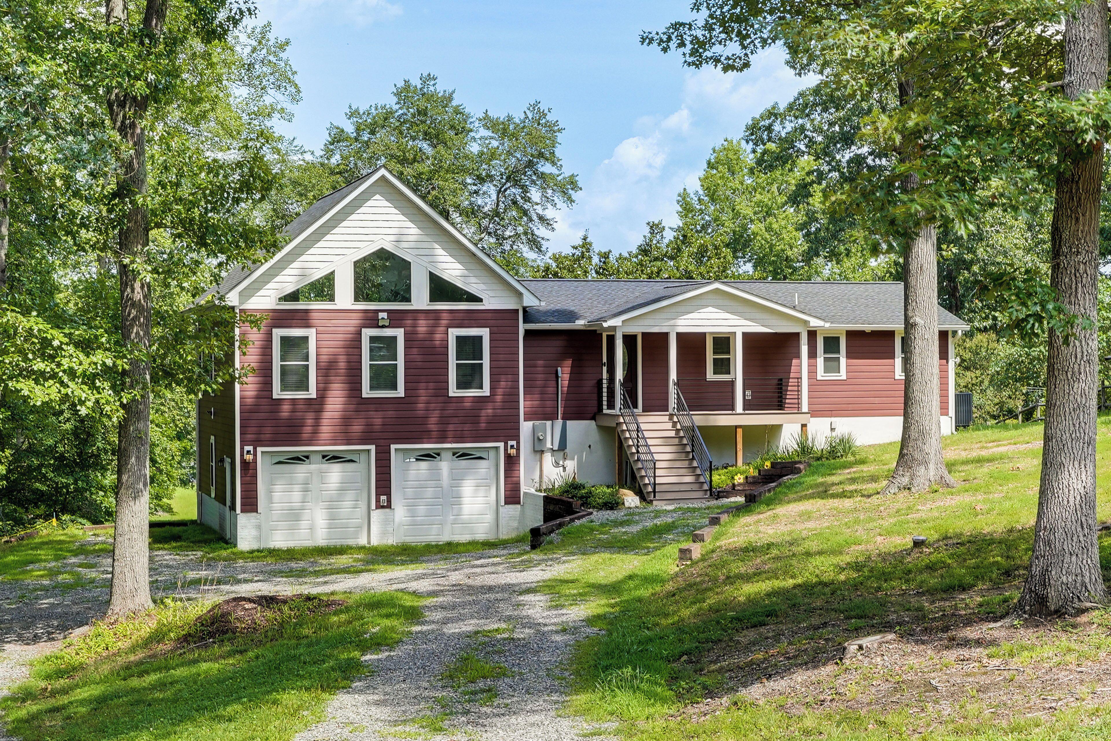 A two-story house with a red exterior, white trim, and a front porch.
