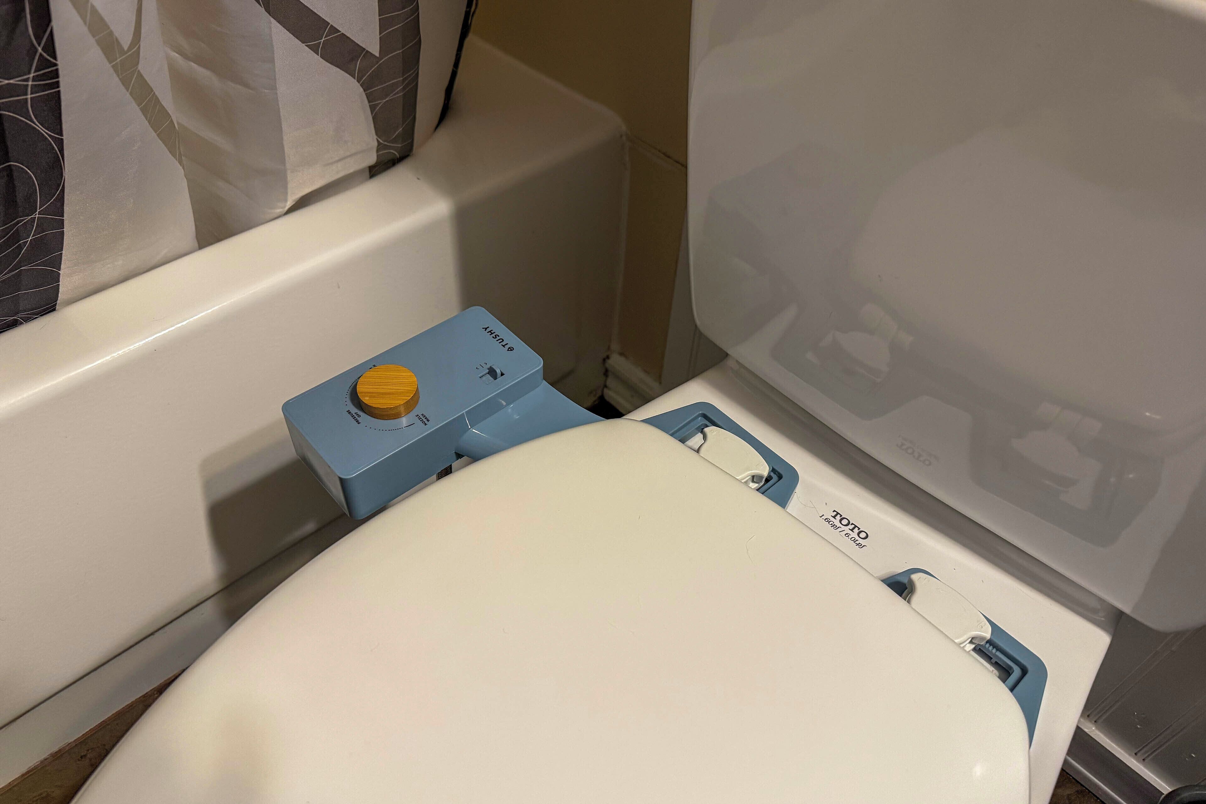 A toilet with a blue tank and a white seat, a blue control panel, and a visible water level indicator.