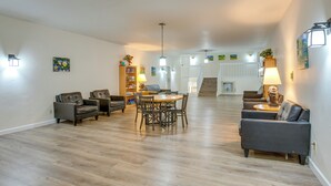 A spacious living area with a dining table, sofas, and a staircase leading to another level. - Heated Pool & Hot Tub! Winter Park Mtn Retreat (Winter Park)