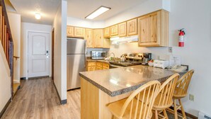 A kitchen with wooden cabinets, a stainless steel refrigerator, a microwave, and a coffee maker. - Heated Pool & Hot Tub! Winter Park Mtn Retreat (Winter Park)