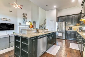 A modern kitchen with a central island, stainless steel appliances, and a built-in dishwasher. - Modern Home w/ Office: Near Parks, Lake & Golf! (Little Elm)