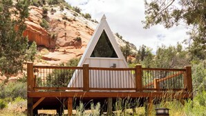 Une structure en bois dotée d’un toit triangulaire, d’une terrasse en bois et d’une enseigne avec des chiffres.