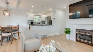 Una cocina moderna con armarios blancos, un refrigerador de acero inoxidable y un horno empotrado.