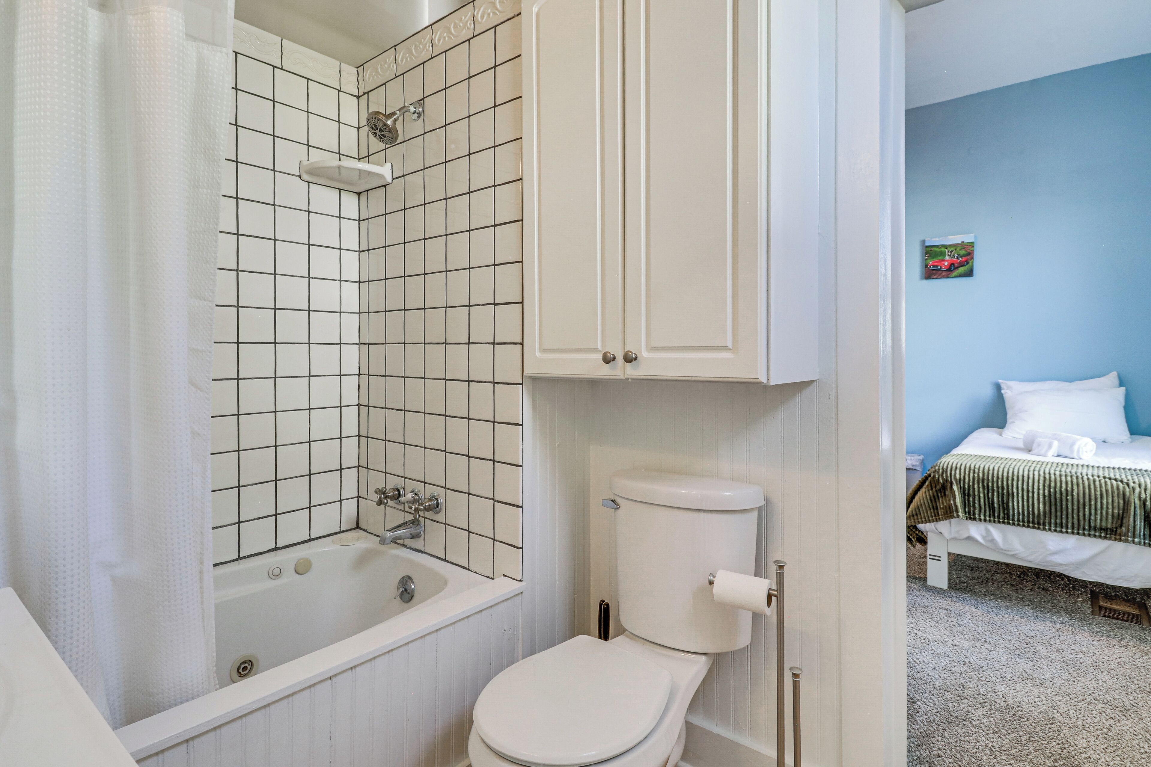 A bathroom with a bathtub, toilet, and a shower.