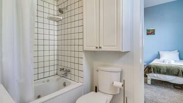 A bathroom with a bathtub, toilet, and a shower.