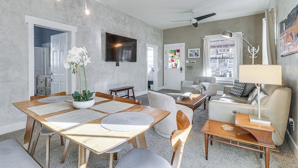 A modern living room with a dining area, a sofa, a TV, and a ceiling fan. - Deck & Home Office: Walkable Albuquerque Home (Albuquerque)