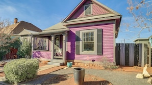 A single-story house with a pink exterior and a dark roof. - Deck & Home Office: Walkable Albuquerque Home (Albuquerque)