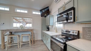 A modern kitchen with a wooden island, stainless steel appliances, and light-colored cabinetry.