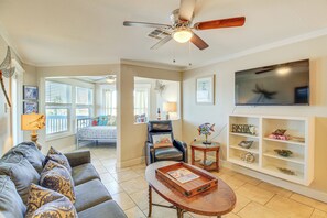 A living room with a sofa, coffee table, TV, and a ceiling fan. - Beach Boardwalk Stay, 10-min Walk, 2-min Drive (Port Aransas)