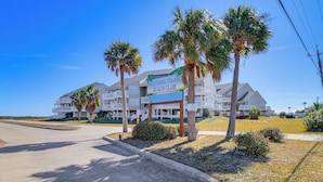 A beachfront hotel with a sign reading "Mustang Island Beach Club." - Beach Boardwalk Stay, 10-min Walk, 2-min Drive (Port Aransas)