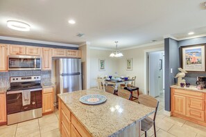 A modern kitchen with granite countertops, stainless steel appliances, and wooden cabinets. - Beach Boardwalk Stay, 10-min Walk, 2-min Drive (Port Aransas)